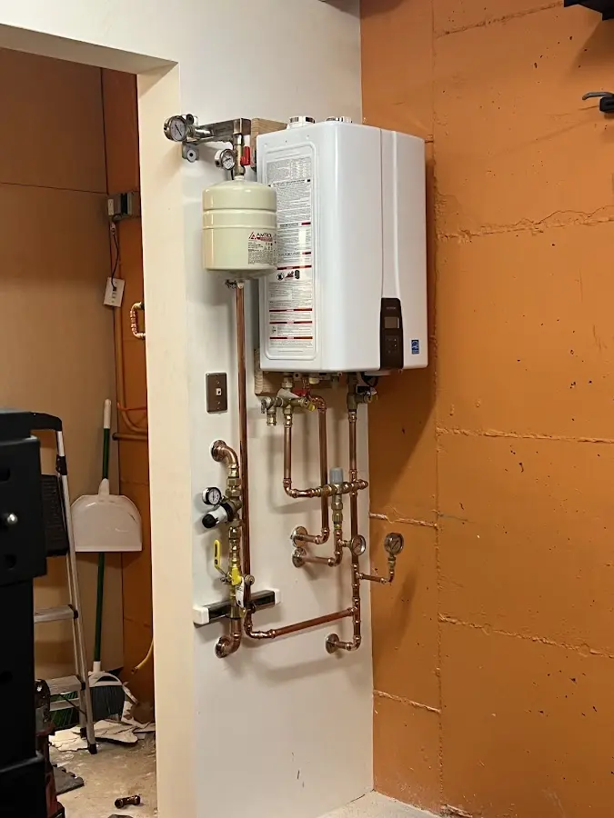 Plumbing technician inspecting water heater connections in Crystal